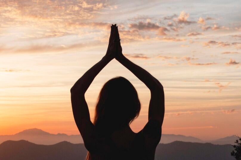 back-view-woman-yoga-pose-sunset