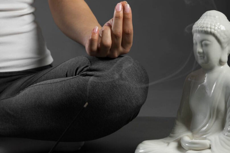 person-meditating-buddha-statuette